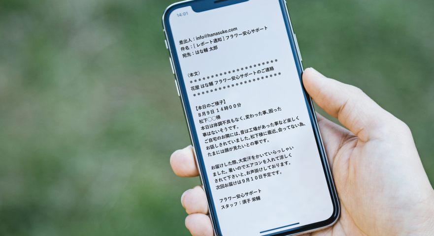 携帯電話で安心サポートのレポートメールを確認する場面
